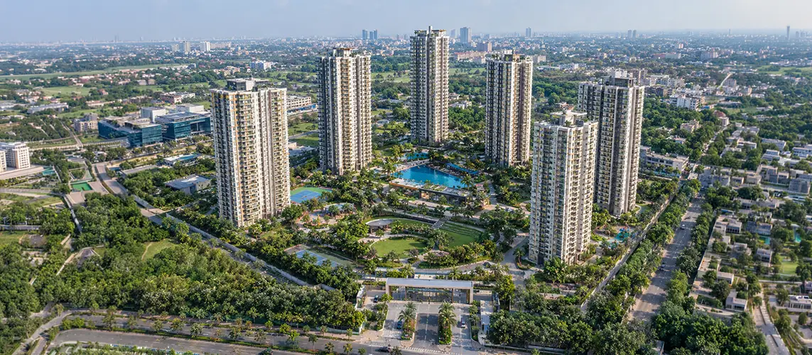 Aerial view of high-rise towers around a central pool and lawns, L&T Aravista banner